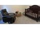 Cozy Bedroom featuring a dark wood crib, comfortable recliner, and playful toy storage at 1346 Ashley Gardens Blvd, Charleston, SC 29414