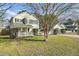 Charming two-story home featuring a picket fence, lush lawn and mature trees at 147 Moon Dance Ln, Summerville, SC 29483