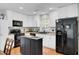 Updated kitchen with white cabinets, black appliances, hardwood floors, and central island at 147 Moon Dance Ln, Summerville, SC 29483