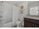 Bathroom with a tub and shower combination, dark wood vanity with granite counters and a dark framed picture at 2014 Barn Swallow Rd, Summerville, SC 29483