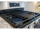 Close up of a gas stove top with stainless steel trim and granite countertops at 2014 Barn Swallow Rd, Summerville, SC 29483