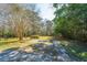 Open backyard with gravel driveway and natural landscaping at 207 S Gum St, Summerville, SC 29483