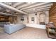 Finished basement featuring an open layout with sofas, exposed ceiling beams, and a decorative fireplace at 207 S Gum St, Summerville, SC 29483