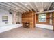 Spacious basement area with white brick fireplace, wooden walls, exposed beams, and ample natural light at 207 S Gum St, Summerville, SC 29483