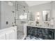 Bright bathroom features a glass shower, dual vanity with marble countertops, and classic black and white flooring at 207 S Gum St, Summerville, SC 29483