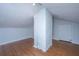 Attic bedroom featuring hardwood floors, white walls, a sloped ceiling, and built-in shelving at 207 S Gum St, Summerville, SC 29483