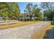 Charming home featuring a white picket fence, lush trees, and a gravel driveway at 207 S Gum St, Summerville, SC 29483