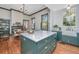 Updated kitchen with center island, marble countertops, stainless appliances, and custom green cabinets at 207 S Gum St, Summerville, SC 29483