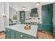 This is a chef's kitchen that includes a large island, lots of cabinet space, and lots of natural light at 207 S Gum St, Summerville, SC 29483