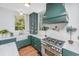 Modern kitchen with a farmhouse sink, stainless steel appliances, marble countertops, and custom green cabinets at 207 S Gum St, Summerville, SC 29483