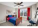 Bright bedroom featuring a bed, desk, and large window with red curtains for natural light at 2124 Tall Grass Cir, Mount Pleasant, SC 29466