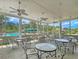 Outdoor seating area with tables and ceiling fans overlooking the pool area and mature trees at 2124 Tall Grass Cir, Mount Pleasant, SC 29466