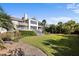 Gorgeous two-story home with lawn, palms, back patios, and a wall of windows at 2238 Catesbys Blf, Seabrook Island, SC 29455
