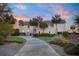 Charming coastal home with a winding driveway, lush lawn, and tropical palm trees at 2238 Catesbys Blf, Seabrook Island, SC 29455