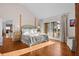 Bright main bedroom featuring light wood floors, a four poster bed, and balcony access at 2238 Catesbys Blf, Seabrook Island, SC 29455