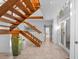 Open staircase featuring wooden steps and white railings, adjacent to a tiled floor and a bright, airy hallway at 2238 Catesbys Blf, Seabrook Island, SC 29455