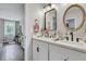Bright bathroom with a double sink vanity, round framed mirrors, and hardwood floors at 2420 Cherokee Hall Ln, Charleston, SC 29414