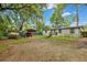 Exterior view of home with a carport, gravel driveway, and spacious yard with mature trees, offering ample parking at 2420 Cherokee Hall Ln, Charleston, SC 29414