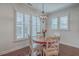 Cozy dining area featuring a round wooden table, plantation shutters, and stylish chandelier at 2615 Rutherford Way, Charleston, SC 29414