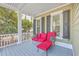 Comfortable front porch seating with vibrant cushions, stylish decor, and views of the yard at 2615 Rutherford Way, Charleston, SC 29414
