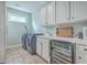 Well-equipped laundry room with modern appliances, ample cabinetry, sink, and wine refrigerator at 2615 Rutherford Way, Charleston, SC 29414
