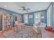 Comfortable office space with blue walls, hardwood floors, bookcases, and two windows at 2615 Rutherford Way, Charleston, SC 29414