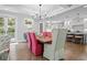 Open-concept dining area with hardwood floors, chandelier, and colorful chairs at 2648 Seabrook Island Rd, Seabrook Island, SC 29455