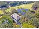 An aerial view showcases the house backing up to a golf course and a pond surrounded by lush green trees at 31 Berkshire Hall, Kiawah Island, SC 29455