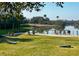 Scenic backyard overlooking a tranquil pond with lounge chairs, cornhole game, and lush landscaping at 31 Berkshire Hall, Kiawah Island, SC 29455