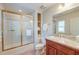 This bathroom features a granite countertop vanity, tiled shower with glass doors, and storage shelves at 31 Berkshire Hall, Kiawah Island, SC 29455