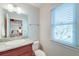 Neutral bathroom with a granite countertop, ample lighting, and a window with plantation blinds at 31 Berkshire Hall, Kiawah Island, SC 29455