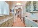 Butler's pantry with marble countertops, glass-front cabinets, and an adjoining living space at 31 Berkshire Hall, Kiawah Island, SC 29455
