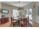 Casual dining area with a round glass table, comfortable chairs, wainscoting, a TV, and access to an outdoor deck at 31 Berkshire Hall, Kiawah Island, SC 29455