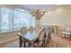 Dining area with large window offering views of the outdoors and a chandelier hanging over a glass-topped dining table at 31 Berkshire Hall, Kiawah Island, SC 29455