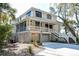 Spacious two-story home with a white exterior, screened porch, and a two-car garage at 31 Berkshire Hall, Kiawah Island, SC 29455