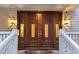 Close up of the beautiful wooden double front doors with glass panels and an elegant outdoor lighting at 31 Berkshire Hall, Kiawah Island, SC 29455