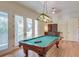 Bright game room with pool table, hardwood floors, and french doors to the outdoor porch at 31 Berkshire Hall, Kiawah Island, SC 29455