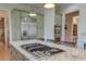 Kitchen island with gas cooktop and granite countertops with stainless refrigerator at 31 Berkshire Hall, Kiawah Island, SC 29455