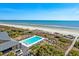 Stunning aerial view of the pool, palm trees, and beachside property with serene ocean backdrop at 31 Berkshire Hall, Kiawah Island, SC 29455