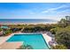 Overhead angle showing the pristine pool and ocean view surrounded by well-maintained greenery and palm trees at 31 Berkshire Hall, Kiawah Island, SC 29455