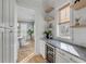 Convenient butler's pantry with wine fridge, marble counters, and open shelving near the dining area at 3699 Goodwater St, Mount Pleasant, SC 29466