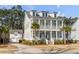 Charming two-story home featuring a double porch, white pillars, complemented by lush landscaping and mature trees at 3699 Goodwater St, Mount Pleasant, SC 29466