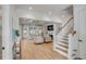 Open-concept living room with coffered ceilings, hardwood floors, and elegant staircase at 3699 Goodwater St, Mount Pleasant, SC 29466