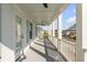 Outdoor porch features a light-colored floor, white railings, and a ceiling fan with views of surrounding houses at 3699 Goodwater St, Mount Pleasant, SC 29466
