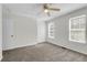 This carpeted bedroom features a ceiling fan and bright windows, complemented by a closet and crisp, white trim at 4722 Whitwil Blvd, North Charleston, SC 29418