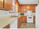 An efficient kitchen features wooden cabinets, a white refrigerator, and appliances at 4722 Whitwil Blvd, North Charleston, SC 29418