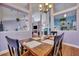 Open-concept dining room featuring hardwood floors, open access to living spaces, and a view to the kitchen at 5420 Percival Ln, North Charleston, SC 29420