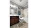 Bathroom with wood vanity, shower-tub combo, tile floor, toilet, and stylish lighting at 615 Ravens Wood Rd, Summerville, SC 29486