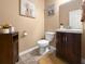 Cozy bathroom with wood vanity, neutral walls, decorative art, a toilet, and a neutral bathmat at 615 Ravens Wood Rd, Summerville, SC 29486