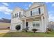 Inviting two-story home showcasing a well-maintained lawn and a cozy front porch with white railings at 615 Ravens Wood Rd, Summerville, SC 29486